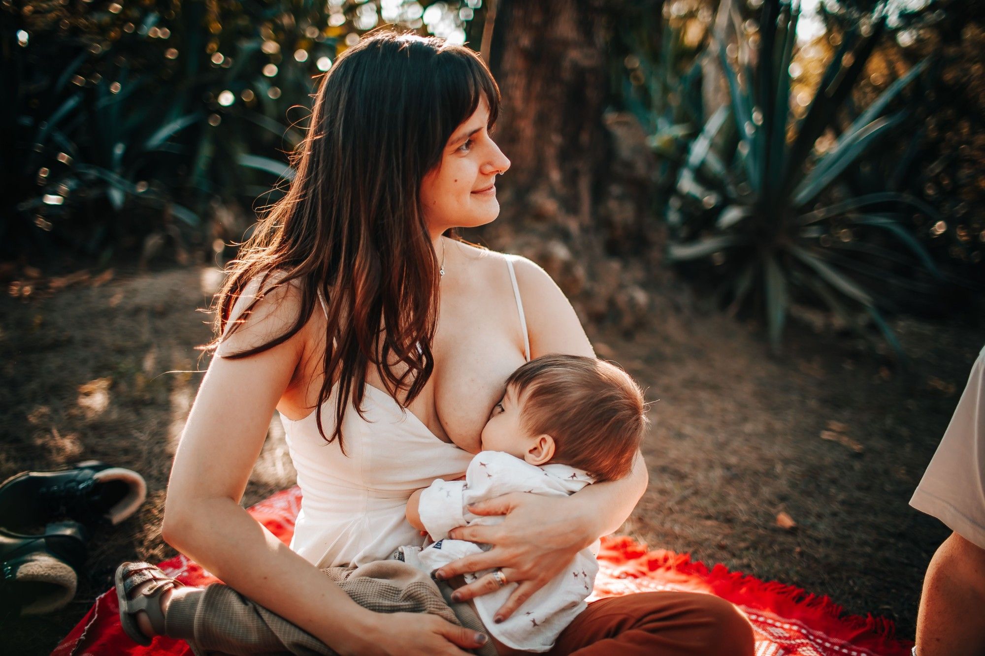 Mother breastfeeding her baby outdoors, the moment Leutoo's lactation and baby care products are designed for